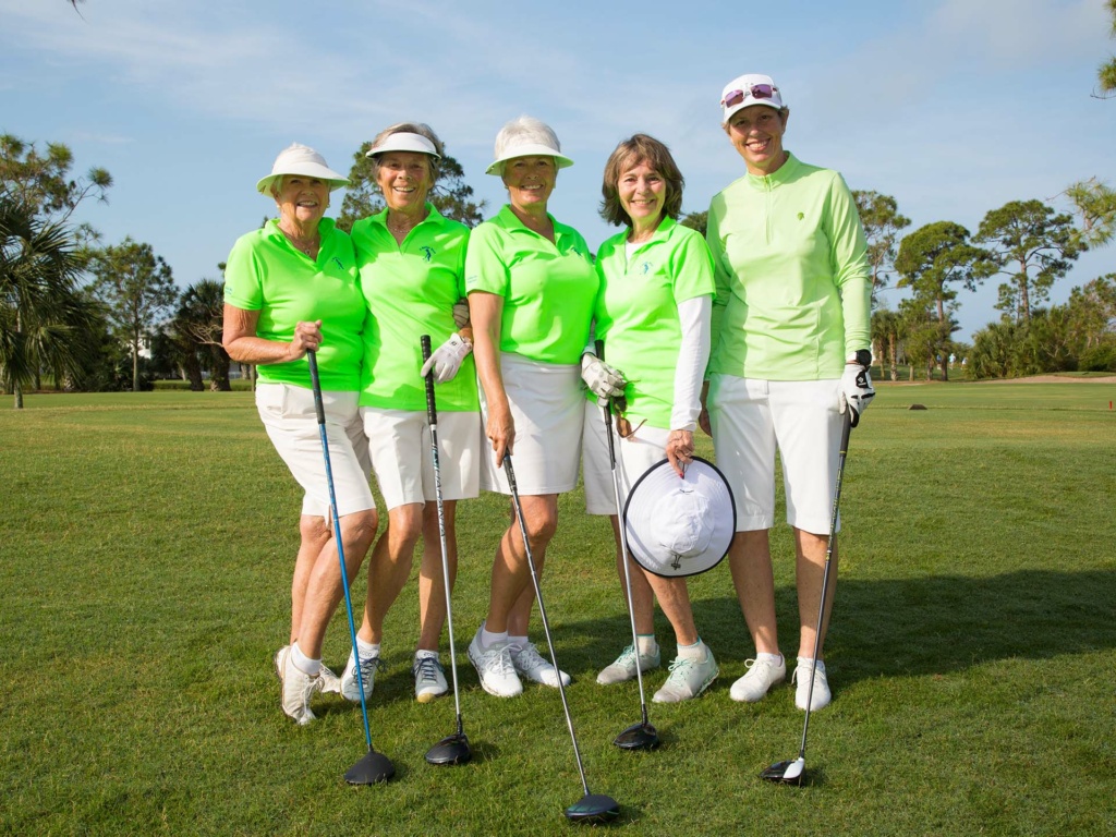 five ladies posing with golf club on golf course