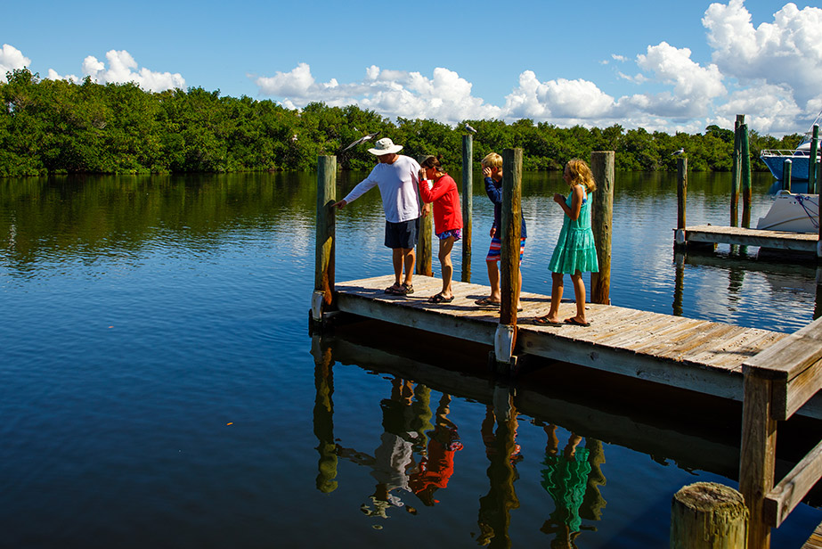 father and kids standing on dock