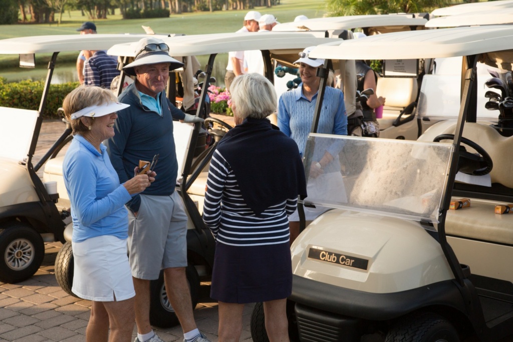 golfers chatting next to golf carts